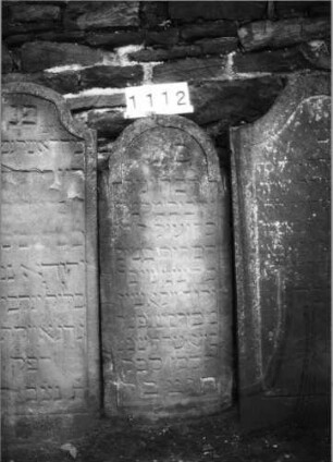 Grabstein 1112 (Index: 99630615) Material: Sandstein Zustand: verwittert Maße HxBxT: 110x46x11 cm Beschreibung: Stele mit eingezogenem Rundbogenabschluß, Schriftfeld eingetieft: Grabstein 1112