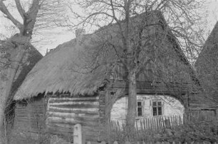 Gebohltes Haus mit Strohdach in Klein Partwitz. : Stara kładźita chěža ze słomjanej třěchu.