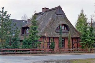 Am Teich / Ecke Dorfstraße: giebelständige Fachwerkkate mit Reetdach: Straßenfront, Fenster mit Butzenscheiben, Fledermausgaube: Traufseite, breite Gaube: vorne Holzzaun