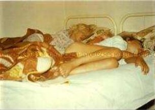 Zwei kleine Mädchen schlafen auf einem Doppelbett (Altersgruppe bis 14)