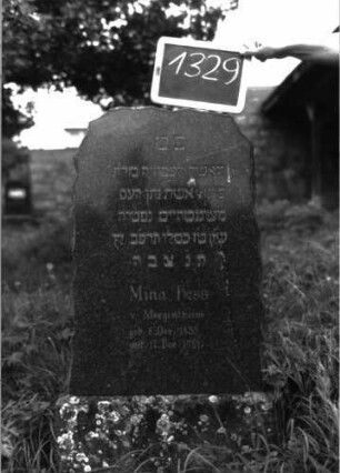 Grabstein 1329 (Index: 100104617) Material: schwarzer Granit Zustand: gut erhalten Maße HxBxT: 78x50x20 cm Beschreibung: aufgesockelte Stele mit Segmentbogenabschluss, Ränder unregelmäßig gestaltet: Grabstein 1329