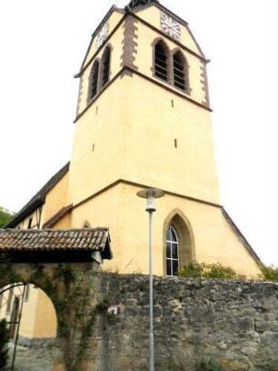 Ansicht von Ostsüdosten mit Kirchtum (Chorturm mit Schlitzscharten im Mittelgeschoß) über Kirchhofmauer sowie Torrest