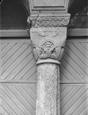 Mittelsäule des Eingangs mit Kapitell mit Masken und Drachen