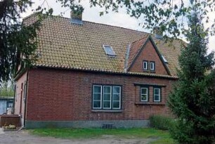 Blumendorf 5: traufständige Doppelkate aus Backstein: Straßenfront mit Sprossenfenster, Zwerchgiebel: Giebelseite mit Eingangstür: vorne Vorplatz: 29. April 2003