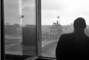 Berlin: Reichstagsgebäude; vom Sitzungszimmer auf Brandenburger Tor mit Mauer; Person im Vordergrund