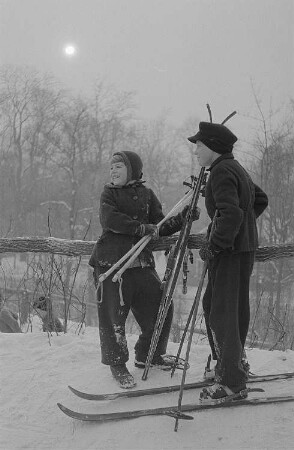 Leipzig, Johannapark. Kinder beim Ski- und Schlittenfahren, Mädchen und Junge im Gespräch kurz vor der Abfahrt im Johannapark in Leipzig