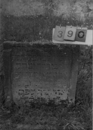 Grabstein 390 (Index: 100107872) Material: gelber Sandstein Zustand: stark verwittert, oberer Teil abgebrochen Maße HxBxT: 62x72x14 cm Beschreibung: Stele, oben abgebrochen, Schriftfeld eingetieft: Grabstein 390