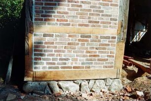 Dorfplatz (2): Fachwerkscheune: Sanierung: Giebelseite, Detailaufnahme: Gebäudeecke, erneuerter Schwellbalken auf Feldsteinfundament, Pfosten und Riegel teilweise nach Erneuerung, Gefache mit neuer Ausmauerung, Türöffnung, Blick in Innenraum: Baumaterialien: 8. August 1994