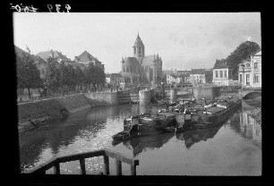 Audenarde (=Oudenaarde, Brügge): Kirche [Notre-Dame de Pamele] an der [Schelde], im Vordergrund Kähne vor einer Kanalschleuse (Distanzaufnahme)