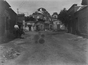 Straßenszene : Straße in einer mexikanischen Ortschaft; im Hintergrund eine Kirche.