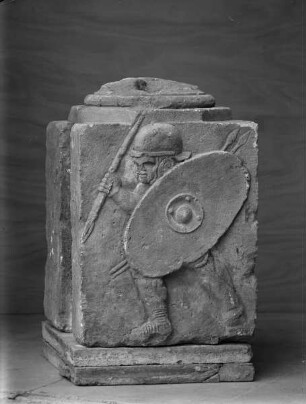 Säulenpostament, Teil einer Säulenhalle. Relief mit einem kämpfenden Legionär