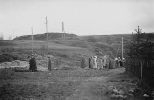 Personengruppe : Eine Personengruppe in einer hügeligen Landschaft.