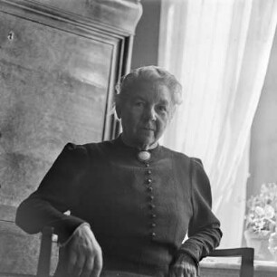 Portrait einer älteren Dame, die am Fenster sitzt