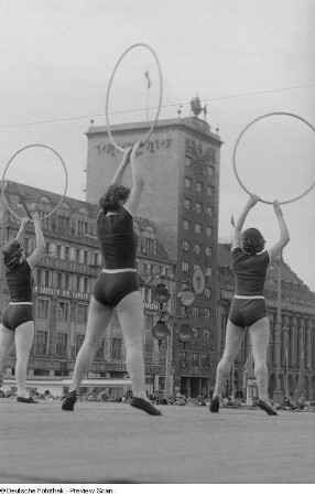 Junge Frauen bei der Vorführung einer Gymnastikübung mit Reifen