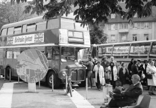 Freiburg: London-Bus auf Tournee am Karlsplatz, mit Singgruppe
