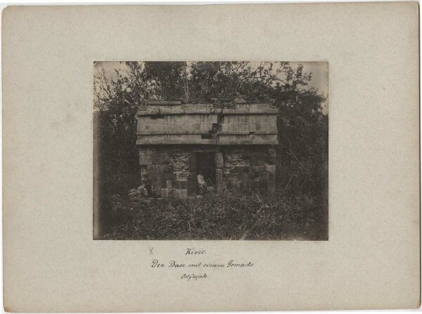 "The building with one room. East facade. (Person sitting in door.)"