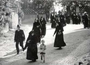 Heimweg von einer Beerdigung in Crostwitz : Kleidung - katholische Tracht. Ort: Chrósćicy / Crostwitz. Auf dem Heimweg nach einer Beerdigung