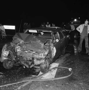 B 404: bei Wolkenwehe: Verkehrsunfall: Auffahrunfall und Zusammenstoß von drei Pkws: Unfallfahrzeug mit eingedrückter Front, Glassplitter, Wasserschlauch: hinten Feuerwehrleute der Freiwilligen Feuerwehr Bad Oldesloe, Helfer, Zuschauer: hinten links Wegweiser nach Tralau: im Dunkeln