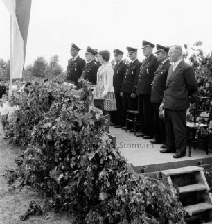 Klein Wesenberg: Amtsfeuerwehrfest des Amtes Reinfeld-Land: Fahnenweihe der neuen Fahne der Amtsfeuerwehr: Prolog zur Fahnenweihe von Edith Dunkelguth: Podium mit stellvertretendem Landesverbandswehrführer August Schleßmann, Heide, Kreisbrandmeister Hinrich Harms, Amtswehrführer Willy Stüven, Barsbüttel, Ernst Relling, Bünningstedt, Willy Peemöller, Todendorf sowie Bürgermeister Ewald Prahl