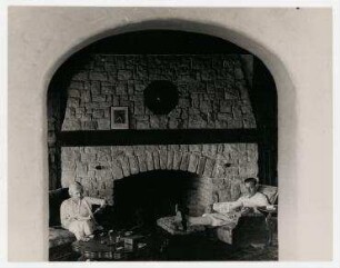 Die Schauspielerin Ann Harding und Harry Bannister vor dem Kamin in ihrem Haus in Hollywood. links: Ann Harding, rechts: Harry Bannister