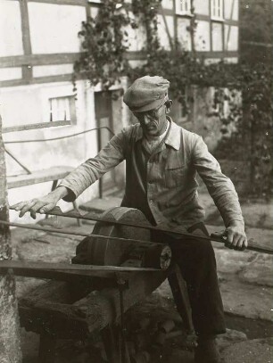 Langenhennersdorf, Schlosserei : Langenhennersdorf, Schlosserei. Schlosser beim maschinellen Schleifen eines Mähmaschinenmessers