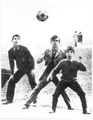 Verfremdete Aufnahme von drei Fußball spielenden Jungen (Altersgruppe 18-21)