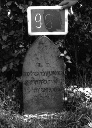 Grabstein 98 (Index: 100100657) Material: Sandstein Zustand: verwittert Maße HxBxT: 57x30x14 cm Beschreibung: Stele, Spitzbogenabschluß Besonderheit: Kindergrab: Grabstein 98