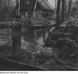 Bauer mit Hund auf einem Kahn im Spreewald