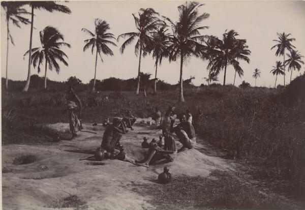 Groupe de personnes assises devant des palmiers