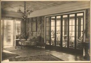 Landhaus Dr. Petz, Berlin-Nikolassee: Innenaufnahme Wohnsalon mit Blick zur geöffneten Gartentür und Wintergarten