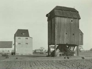 Lichtensee, zwei Windmühlen. Eine hölzerne Bockwindmühle ohne Flügel und eine vermutlich auf Motorantrieb umgerüstete Mühle