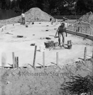 Freibad: Reeshoop: neues Planschbecken in Bau: Arbeiter beim Verstreichen des Betonbodens: Erdhaufen, Schubkarre: hinten Bauzaun
