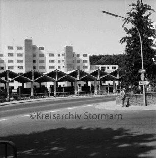 Sülzberg: vorn Einmündung Mommsenstraße: rechts Straßenlampe, Verkehrsschild, Mann und Baum: hinten Gebäude im Bau: dahinter Wohnblocks vor Fertigstellung: 9. August 1975