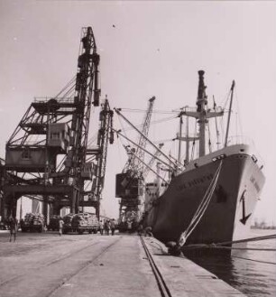 Ghana, Tema, Hafen. Kaianlage mit Portalkranen und Hochseefrachter, um 1960