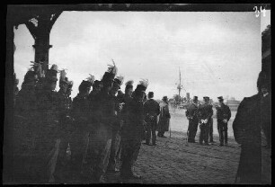 Antwerpen (Belgien): Uniformierte Blasmusik und Honoratioren an den Landungsbrücken (Begrüßung eines Schiffes?) (Rückansicht)