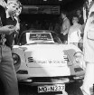 Nickel: Mühlenstraße / Lübecker Straße: Kaufhaus: Besuch durch Fußballnationalspieler und Mannschaftskapitän des Deutschen Meisters Borussia Mönchengladbach Günter Netzer: Eingangbereich: italienischer Sportwagen, Schild an Windschutzscheibe "mit diesem Auto kam Günter Netzer": daneben Männer, Kinder: hinten unter Decke Übersichtstafel über Kaufhaus-Abteilungen