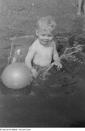 Kleiner Junge, mit einem Ball im Wasser spielend