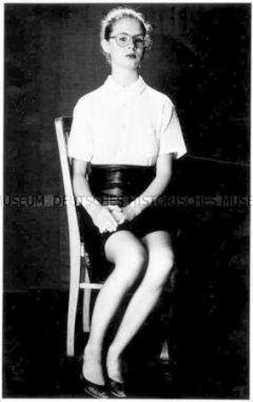 Junge Frau in schwarzem Minirock auf einem Stuhl sitzend (Prämiertes Foto Sonderthema: Kleider machen Leute)