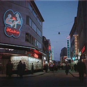 Köln. Leuchtreklame : Köln, Geschäftsstraße mit Leuchtreklame, April 1954