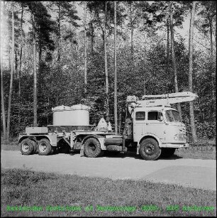 Fahrzeug mit Transportbehälter für feste radioaktive Abfälle und hydraulischem Ladekran