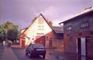 Timmerhorn: Klein Hansdorfer Straße (20): traufständiges Bauernhaus: Giebelseite Wirtschaftstrakt mit Scheunentor, Stalltüren, in Giebel Luke: davor Hof, Misthaufen: rechts traufständiges Wirtschaftsgebäude mit Stalltür, Drempel mit Verbretterung