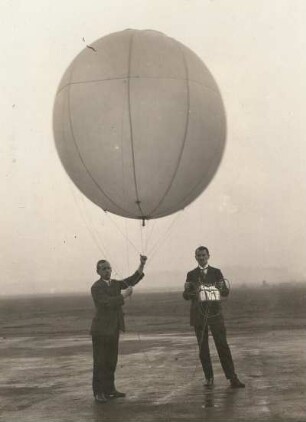 Zwei Männer mit einem Registrierballon