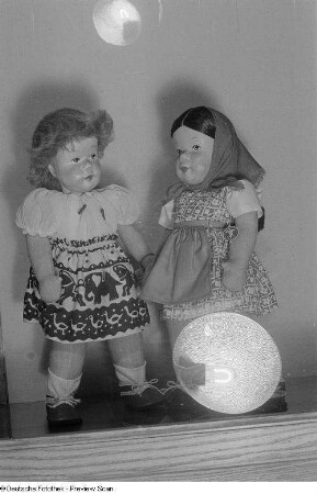 Puppen der Leipziger Herbstmesse 1954 in einer Vitrine, im Glas die Spiegelung des verwendeten Blitzgerätes