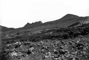 Vulkanlandschaft : Blick auf einen Hang mit Lavablöcken. Im Hintergrund Vulkane.