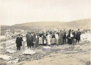 Reykjavík (Island). Gruppenbildnis von Touristen und Einheimischen bei der Klippfischgewinnung