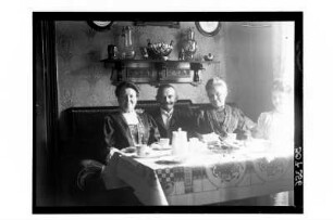 Gruppenbild am Kaffeetisch : Deutschland? Ehepaar Patzig, rechts u.a. Personen an einer Kaffeetafel in einem Wohnzimmer, um 1910/1920