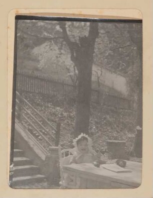 Christiane von Hofmannsthal als Baby im Rodauner Garten am Tisch sitzend