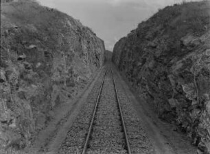 Eisenbahnschienen : Schienen einer Eisenbahn, für deren Verlegung eine Schneise in einen Felsen gehauen wurde