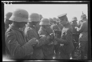 Bei Focșani (Rumänien): Offiziere mit Schirmmütze und mit Pickelhaube beim Verleihen von Auszeichnungen an Soldaten mit Stahlhelm (Nahaufnahme) ("Kaiserparade")