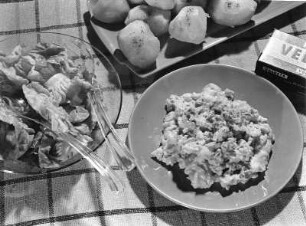 Krafts Rezeptaufnahme : Krafts Rezeptaufnahmen. Platte mit Pellkartoffeln und Teller mit Gemüse, wohl Blumenkohl mit Rahmkäse "Velveta". Daneben eine Schale mit grünem Salat